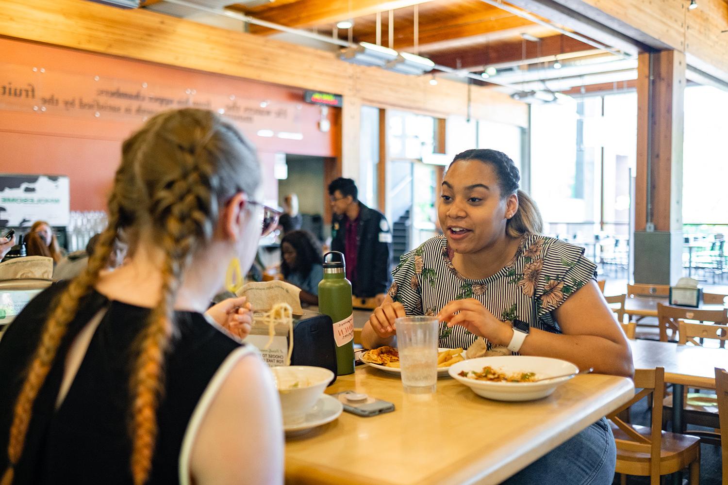 Two people eat in Gwinn Commons | photo by Chris Yang